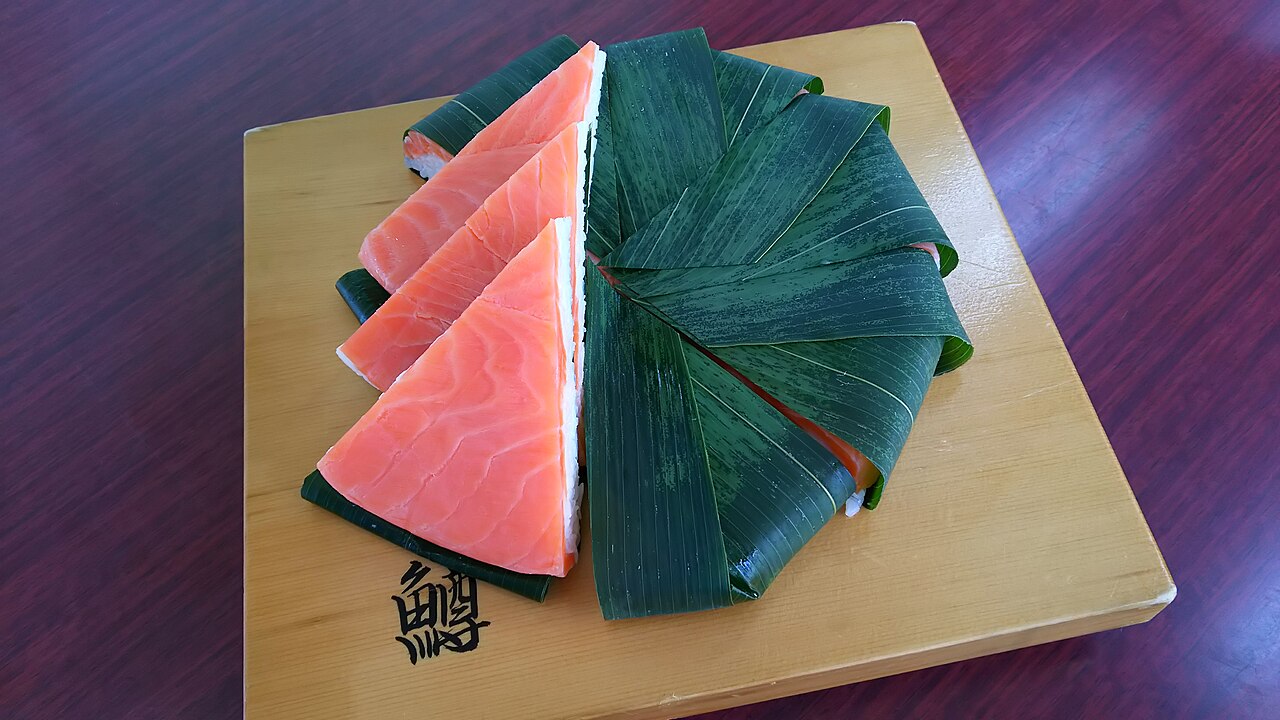 笹の葉ごと切り分けたますのすしの断面と鮮やかなサクラマス