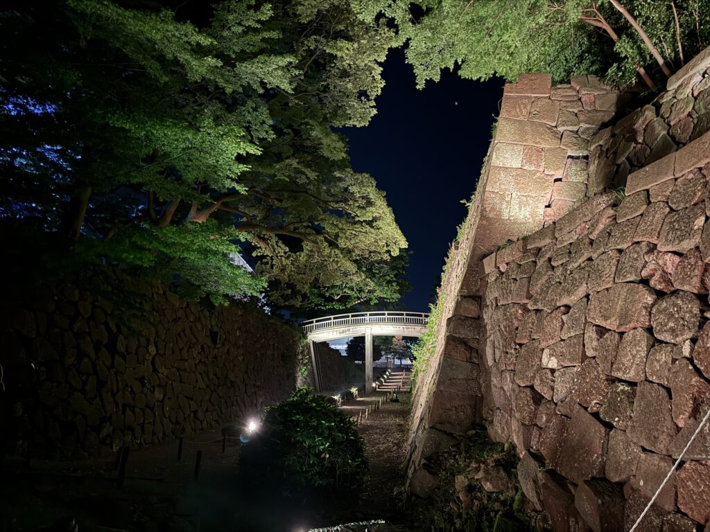夜間ライトアップされた金沢城の石垣と橋