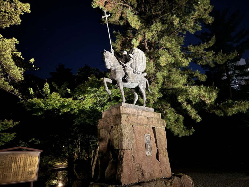 夜間ライトアップされた尾山神社境内の前田利家公像