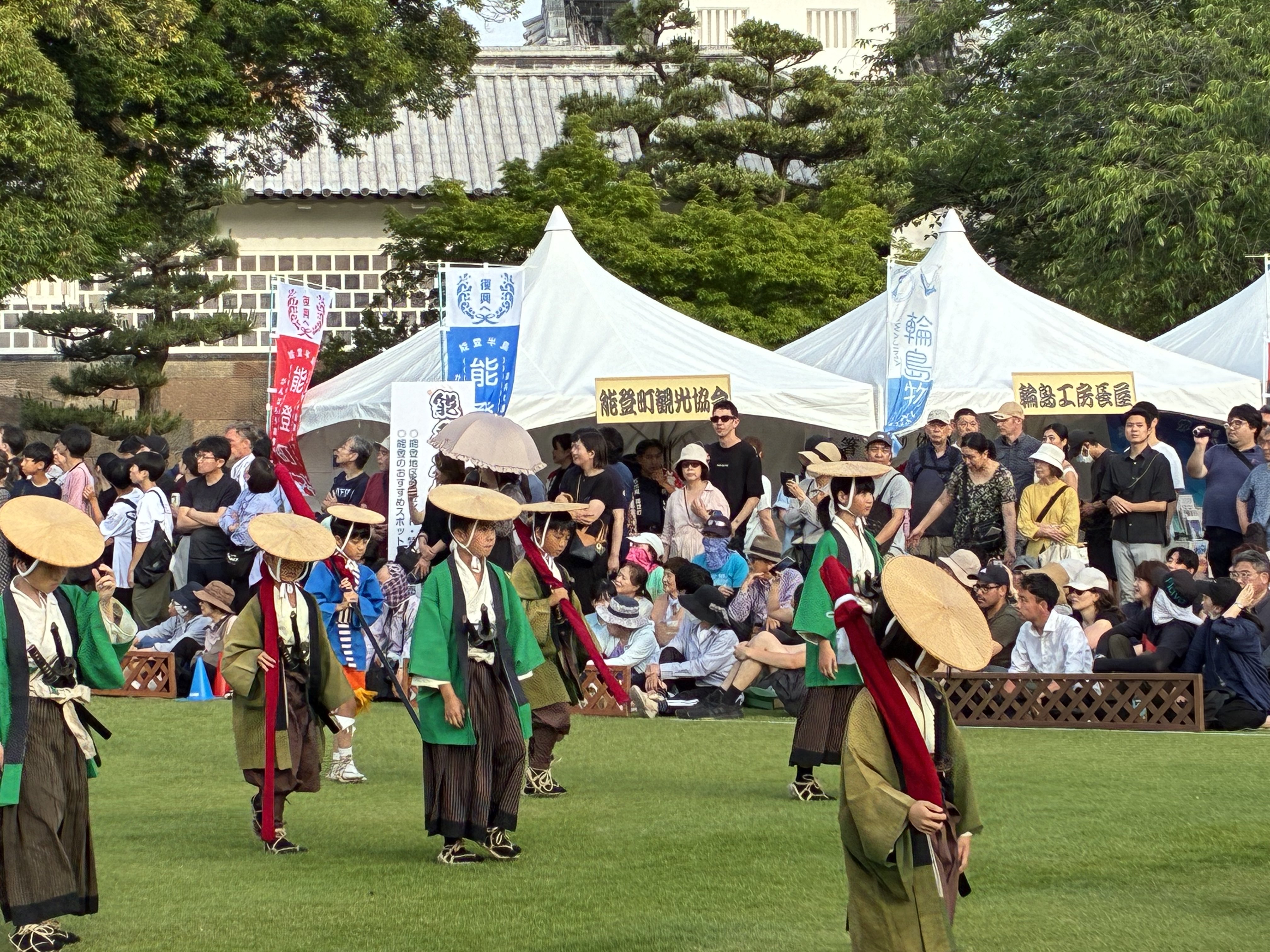 菅笠をかぶった子ども奴行列が金沢城公園を行進