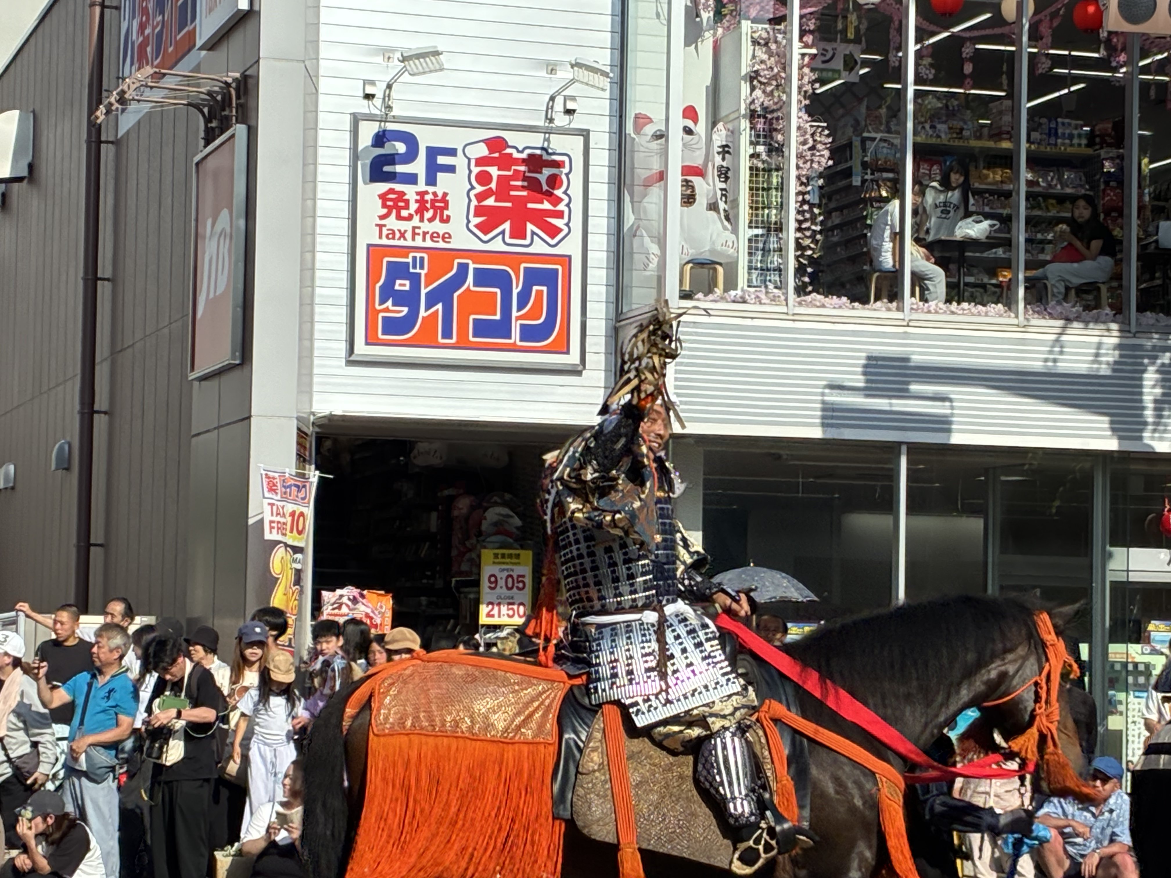 市街地を騎馬で進む甲冑姿の武将