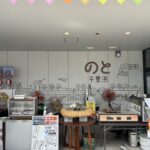 道の駅のと千里浜の軒下に並ぶ焼だんごや醤油フランクの屋台コーナーと施設名の壁画
