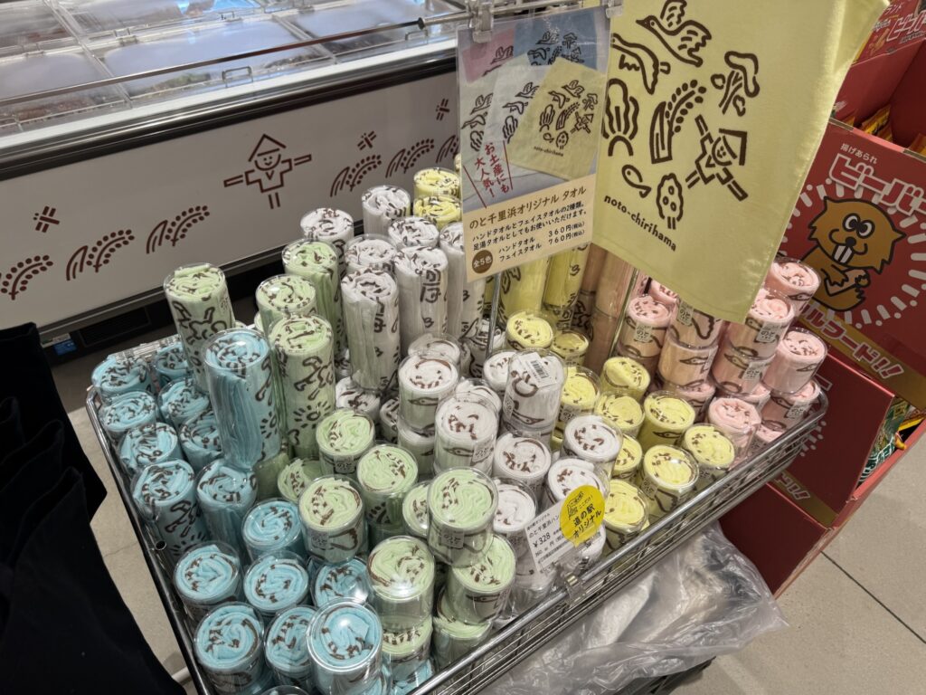 全5色ののと千里浜オリジナルタオルが積まれた売り場