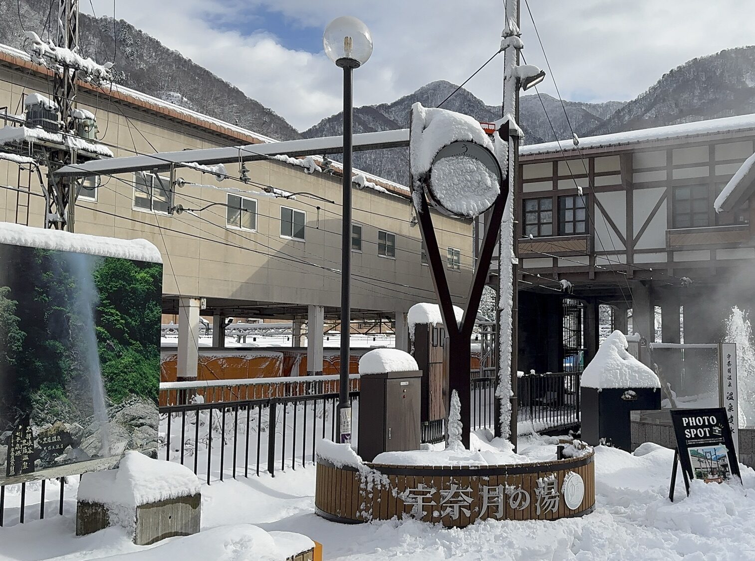 雪の宇奈月温泉駅前で湯けむりを上げる温泉噴水