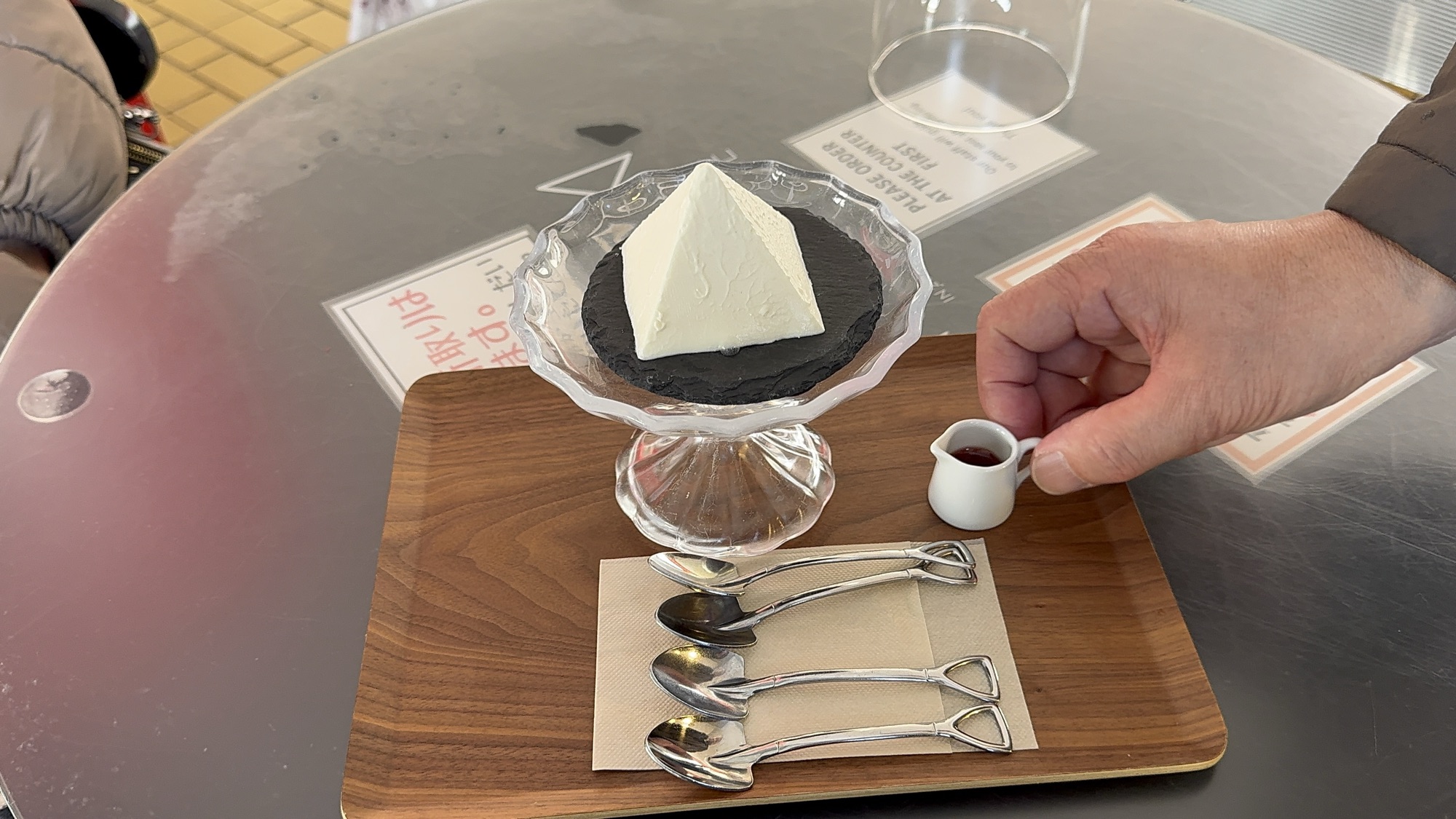 黒い石皿にのった白いピラミッド形のアルペンチーズケーキ