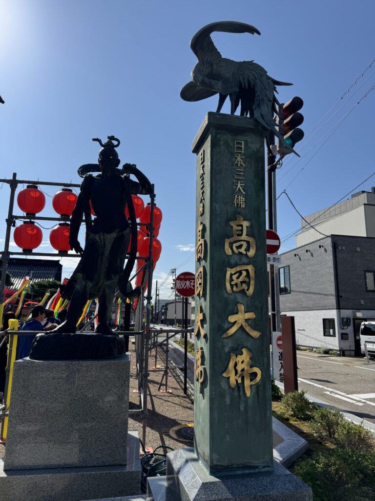 高岡大仏の境内入口に立つ鳳凰をいただいた「日本三大佛 高岡大佛」の標柱と仁王像