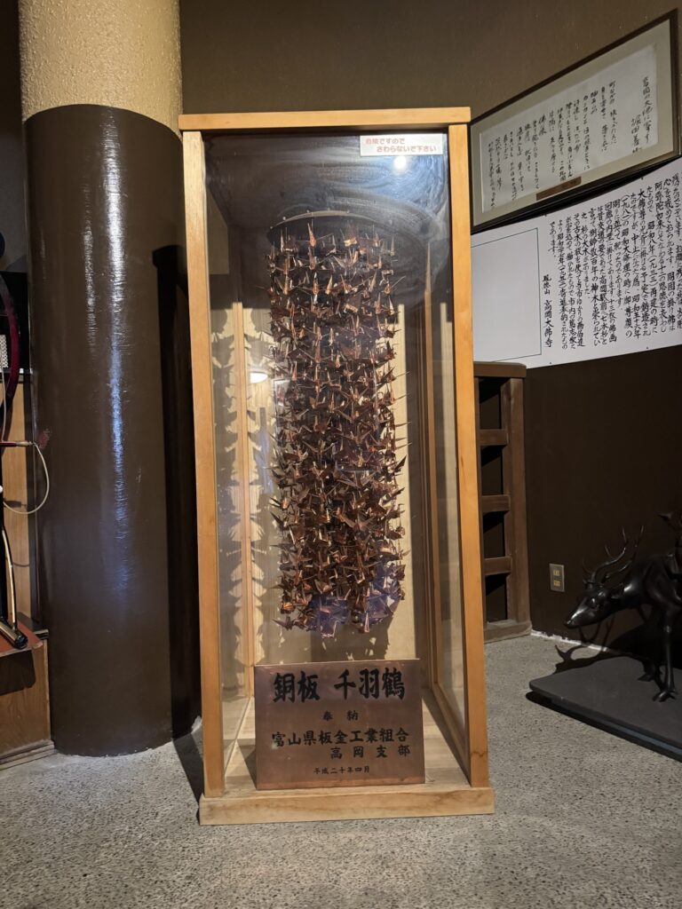 高岡大仏の回廊に展示された、富山県板金工業組合高岡支部奉納の銅板千羽鶴